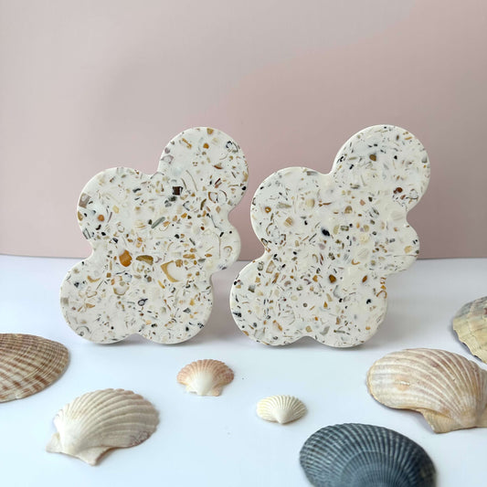 Cloud shaped coasters made with sand and shells and a white base